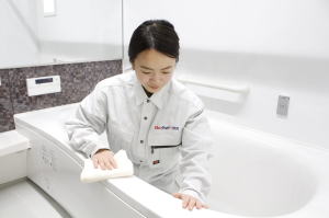 お風呂をクリーニングする男性スタッフ